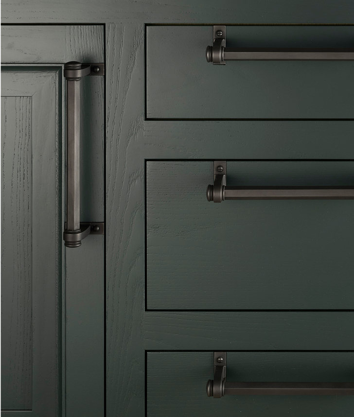 Solid bar pulls are anchored by distinctive wrapped brackets that offer both visual weight and architectural precision.